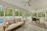 Sunroom / solarium featuring outdoor dining space, an outdoor hangout area, view of scattered trees, and a ceiling fan
