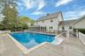 View of pool with a sunroom and a wooden deck
