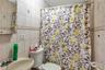 Full bath featuring tile walls and curtained shower