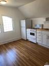 Kitchen featuring white appliances, lofted ceiling, white cabinetry, dark wood-style flooring, and open shelves
