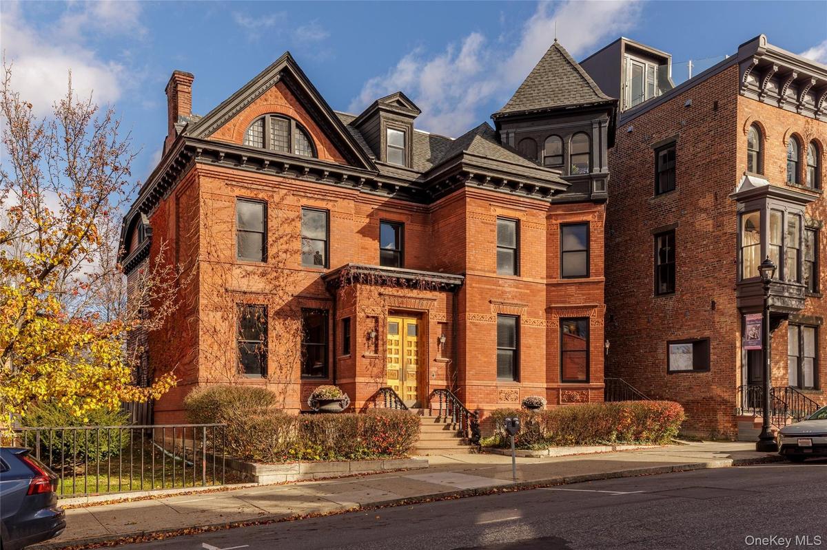 View of front of property with a chimney and brick siding