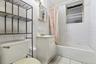 Full bath with shower / tub combo, vanity, light tile patterned floors, and tile walls