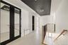 Hallway featuring a tray ceiling, french doors, radiator heating unit, and an upstairs landing