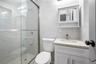 Full bathroom featuring tile walls, a marble finish shower, and vanity