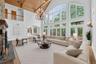 Virtually Staged Living room with a chandelier, arched walkways, a wood ceiling with exposed beams, high vaulted ceiling, and wood finished floors