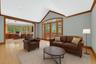 Virtually Staged Living room with ornamental molding, built in desk, light wood-type flooring, and high vaulted ceiling