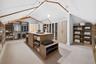 Virtually Staged Walk in closet featuring vaulted ceiling and light carpet