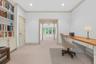 Virtually Staged Office area with built in study area, light carpet, french doors, ornamental molding, and recessed lighting