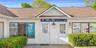 Doorway to property featuring roof with shingles and stucco siding