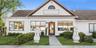 View of front of property featuring a shingled roof, stucco siding, and a front lawn