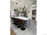 Kitchen with light countertops, lofted ceiling, open shelves, a kitchen breakfast bar, and a peninsula