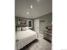 Bedroom with wood tiled floors, vaulted ceiling, and recessed lighting