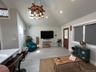 Living area featuring a chandelier, wood tiled floors, and high vaulted ceiling