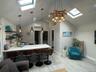 Kitchen featuring a skylight, a peninsula, a kitchen breakfast bar, decorative light fixtures, and light wood-type flooring