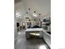 Kitchen featuring a peninsula, pendant lighting, open shelves, a skylight, and vaulted ceiling