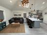 Kitchen featuring open shelves, a kitchen breakfast bar, decorative light fixtures, a peninsula, and a chandelier