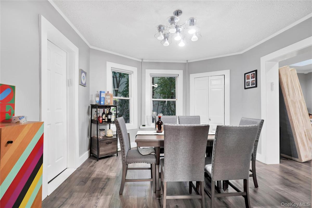 Dining space featuring dark wood-style floors and ornamental molding
