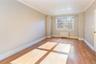 Empty room featuring radiator, light wood-type flooring, and crown molding