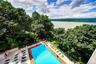 Community pool with a forest view, a patio, and a water view