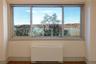 Unfurnished room with radiator, healthy amount of natural light, and dark wood-style flooring
