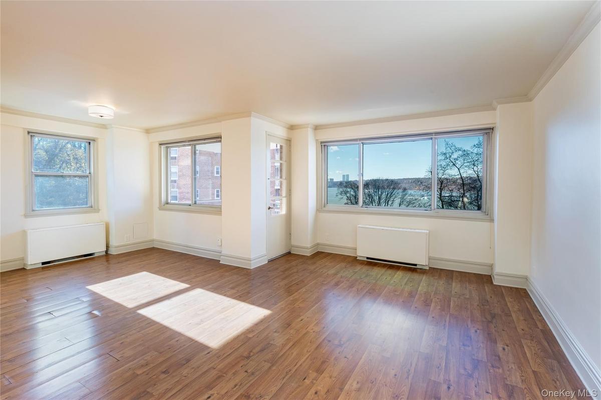 Unfurnished room with radiator heating unit, hardwood / wood-style floors, and crown molding