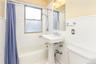 Bathroom with shower / tub combo with curtain and tile walls