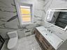 Bathroom featuring vanity, radiator heating unit, and light marble finish flooring