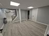 Finished basement featuring stairs, light wood-type flooring, and washer / dryer