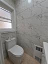 Bathroom with tile walls, vanity, radiator heating unit, and heating unit