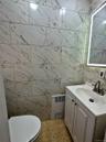 Bathroom with tile walls, vanity, and radiator