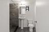 Bathroom featuring a tile shower and toilet