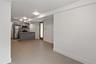 Kitchen featuring a peninsula, gray cabinetry, stainless steel appliances, decorative backsplash, and light countertops