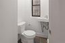 Half bathroom featuring toilet and baseboards