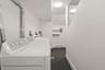 Washroom with independent washer and dryer and a baseboard radiator