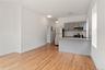 Kitchen with gray cabinets, appliances with stainless steel finishes, backsplash, a peninsula, and light wood-style flooring