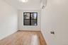 Unfurnished room with light wood finished floors and an AC wall unit