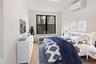 Bedroom featuring a wall unit AC and light wood-style flooring
