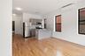 Kitchen with gray cabinetry, appliances with stainless steel finishes, light wood finished floors, a peninsula, and a wall unit AC