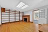 Unfurnished living room with a fireplace, light wood-style floors, and baseboard heating