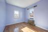 Empty room featuring radiator heating unit and hardwood / wood-style flooring