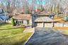Tri-level home with stone siding, driveway, and a garage