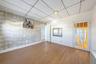 Empty room with a paneled ceiling, wood finished floors, and wallpapered walls