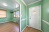 Foyer entrance featuring ornamental molding, radiator heating unit, and light wood finished floors