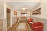 Corridor featuring wainscoting, wood finished floors, a decorative wall, and crown molding