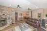 Living area with a fireplace, wainscoting, wood finished floors, a ceiling fan, and recessed lighting