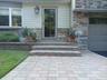 Property entrance featuring stone siding and a garage