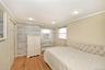 Bedroom featuring hardwood / wood-style floors, crown molding, radiator heating unit, recessed lighting, and a closet