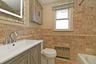 Full bathroom with radiator, vanity, a bath, a shower with shower curtain, and tile walls