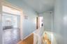 Hallway with an upstairs landing, radiator, and light wood-style floors