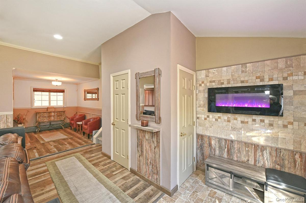 Living room with a wainscoted wall and ornamental molding